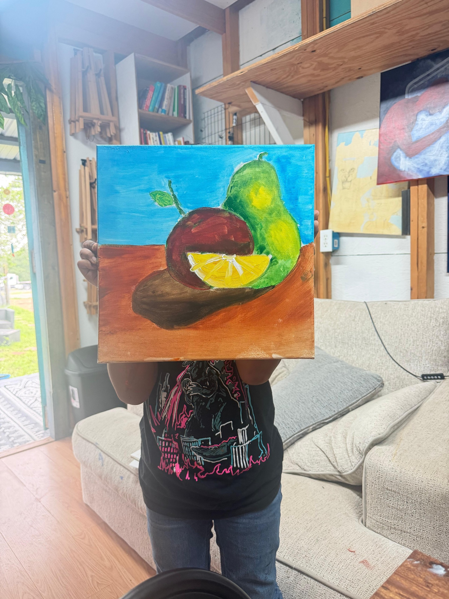 Child showing a still life painting of fruit
